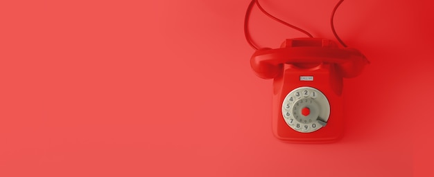 Ein rotes Weinlesetelefon mit rotem Hintergrund.