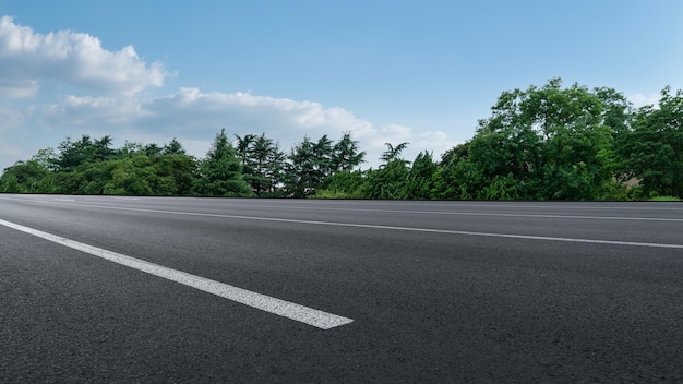 Ein ruhiger Ausblick auf die Straße mit üppigem Grün unter einem hellen Himmel