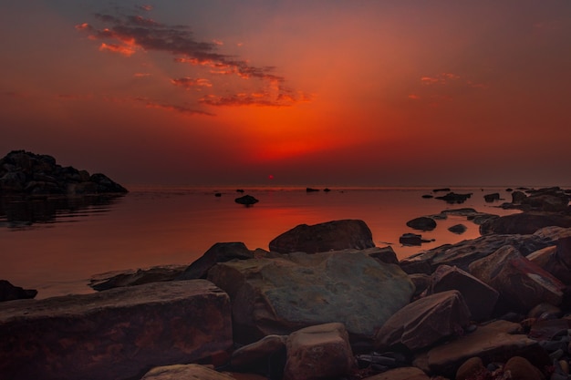 Ein ruhiges Meer mit einem Sonnenuntergangshimmel und der Sonne durch die Wolken darüber Meditation Ozean und Himmel Ruhige Meereslandschaft Der Horizont über dem Wasser