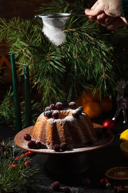 Ein runder Cupcake auf dunklem Hintergrund wird mit Puderzucker bestreut