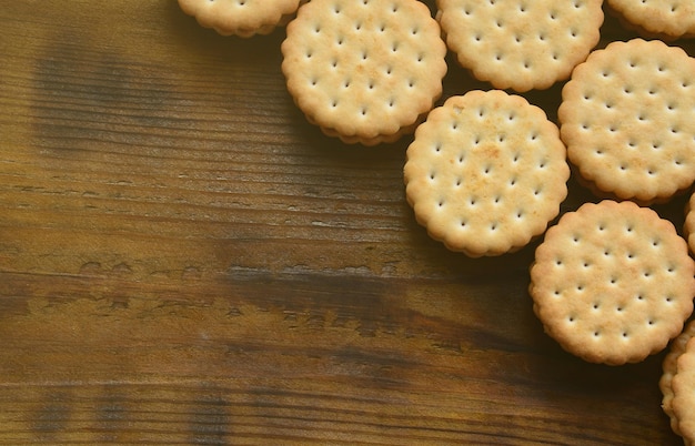 Foto ein runder sandwich-keks mit kokosnussfüllung liegt in großen mengen auf einer braunen holzoberfläche