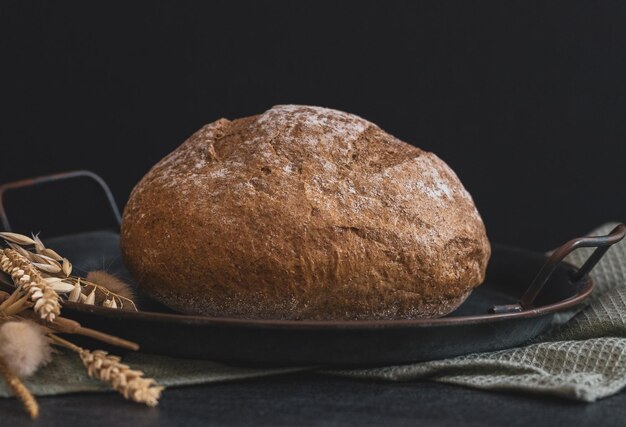 Ein rundes Roggenbrot auf schwarzem Hintergrund