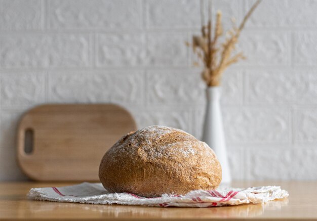 Ein rundes Weißbrot mit Weizenfaser auf dem Tisch