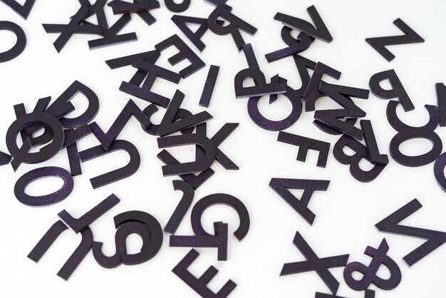 Ein Sammlungssatz von zufällig geschnittenen Buchstaben des Alphabets abstrakt über dem flachen Laienkonzept