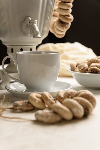 Ein Samowar mit Bagels und heißem Tee auf der weißen Tischdecke