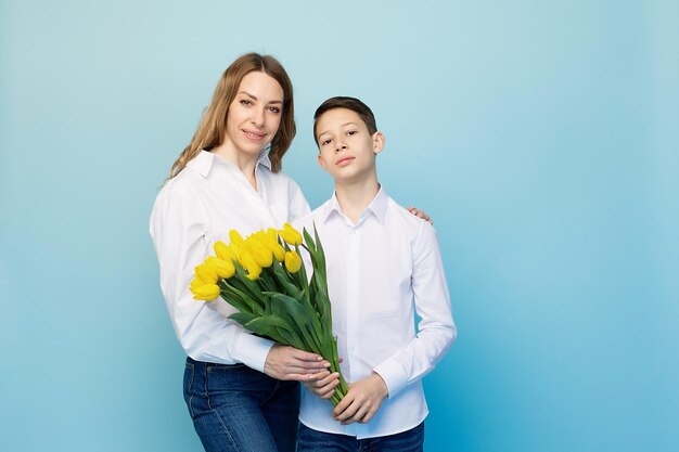 Ein sanfter Sohn gratuliert einer glücklichen Mutter und schenkt ihr einen Strauß Tulpen