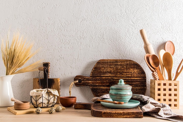 Ein Satz hausgemachter Holzschneidebretter im Inneren einer modernen Küche eines Landhausdorfes aus Holz mit Küchenutensilien