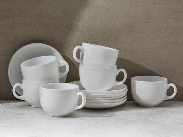 Ein Satz weißes Keramikgeschirr auf dem Tisch, Tassen und Untertassen für Tee oder Kaffee