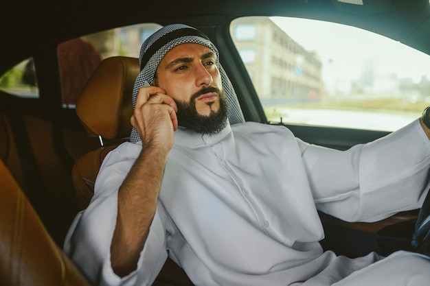 Ein saudischer Mann sitzt in einem Auto und telefoniert