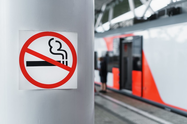 Ein Schild, das das Rauchen auf einer Stange in der Nähe des Bahnsteigs verbietet.