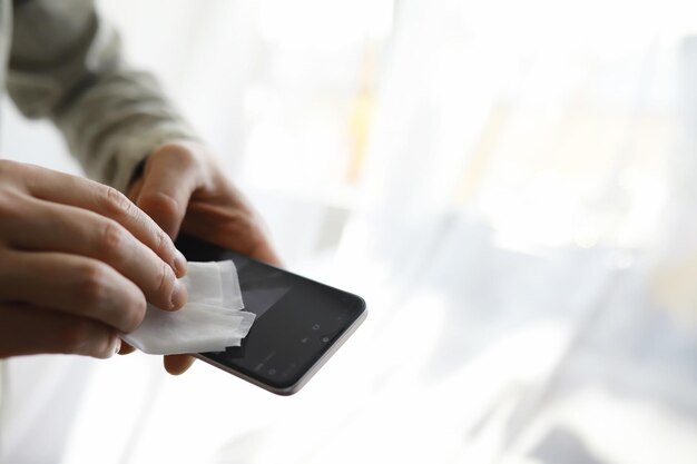 Ein schlankes Konzept. Wischen Sie Schmutz von Oberflächen ab. Desinfektionsbehandlung des Telefonbildschirms. Sanitäre Behandlung zu Hause in Quarantäne.