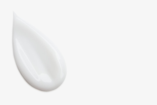 Ein Schmier von weißer Kosmetikcreme auf einem hellen Hintergrund