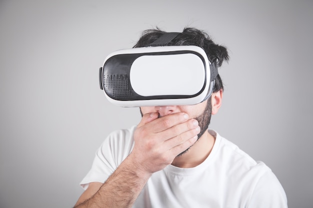 Ein schockierter Mann mit einer VR-Brille bedeckt seinen Mund.