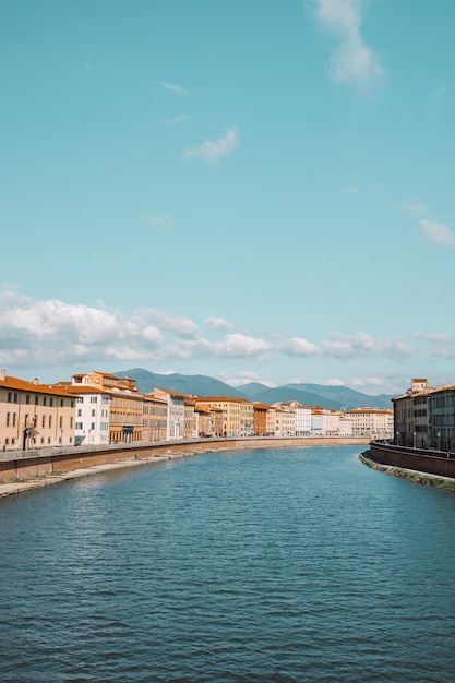 Ein schöner Blick auf die Gebäude entlang des Flusses Arno in Pisa Italien Eine Brücke führt über den Fluss und die Häuser auf beiden Seiten überblicken das Wasser