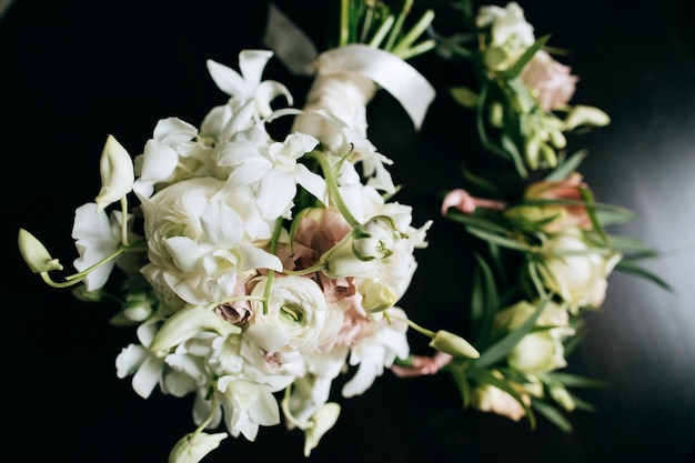 Ein schöner Hochzeitsstrauß von Bräuten aus weißen Blumen auf dunklem Holzhintergrund x9