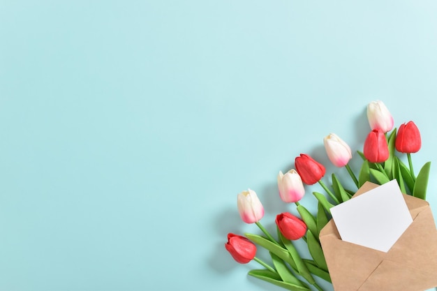 Ein schöner Strauß Tulpen in einer Öko-Tasche auf hellblauem Hintergrund Internationaler Frauentag M