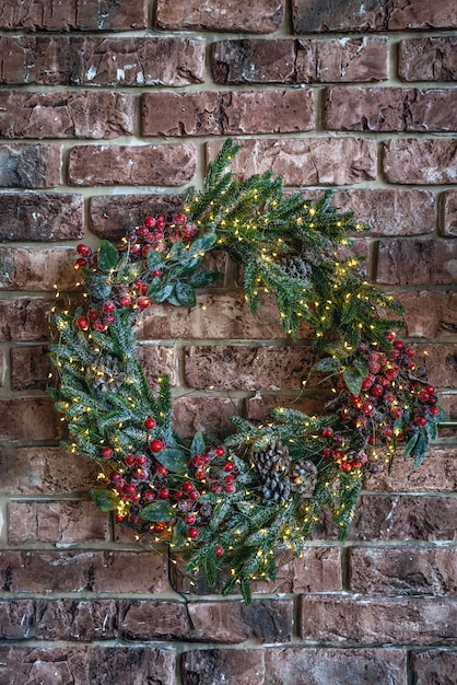 Ein schöner Weihnachtskranz isoliert auf einem Backsteinmauerhintergrund Handgemachter Weihnachtskranz