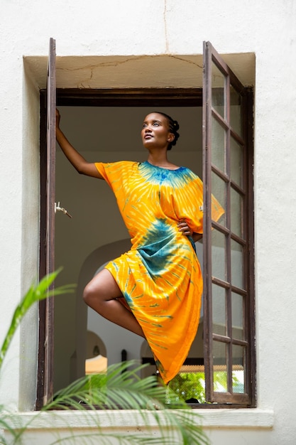 Ein schönes afrikanisches Mädchen steht im Fenster.