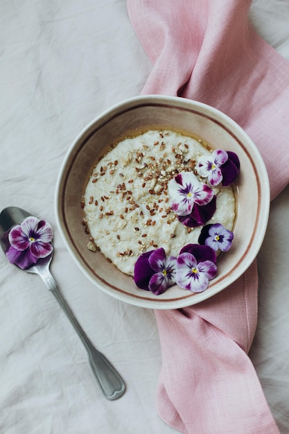 Ein schönes Frühstück aus Haferbrei, dekoriert mit essbaren Naturblumen