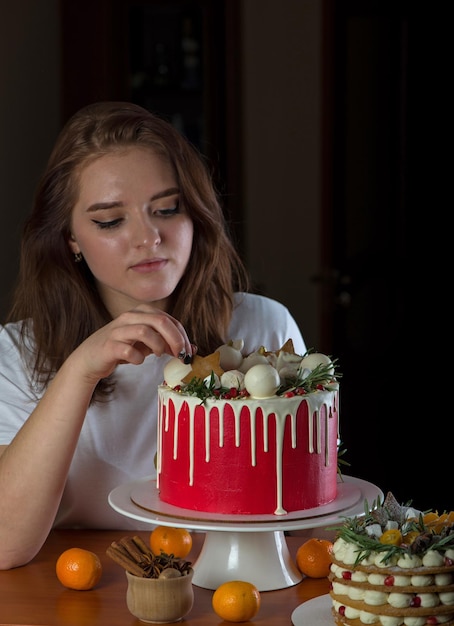 Ein schönes glückliches Mädchen zu Hause hält einen festlichen Neujahrskuchen auf einem Teller