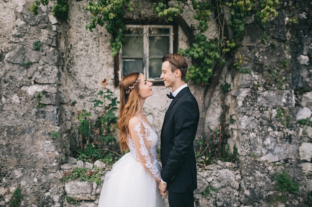 Ein schönes Hochzeitspaar geht in eine feenhafte österreichische Stadt, Hallstatt.