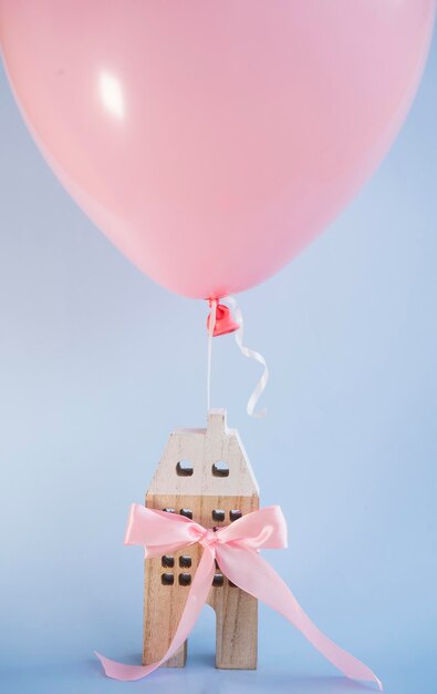 Ein schönes Holzhaus ist an einen rosa Ballon gebunden