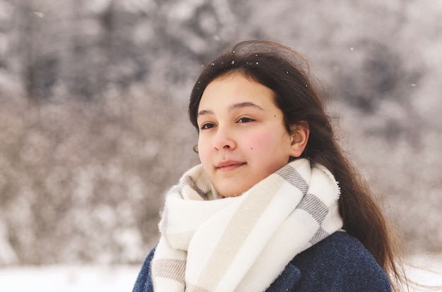 Ein schönes junges Mädchen schaut in der Ferne in die Natur des Winters. Nachdenklichkeit und Verträumtheit