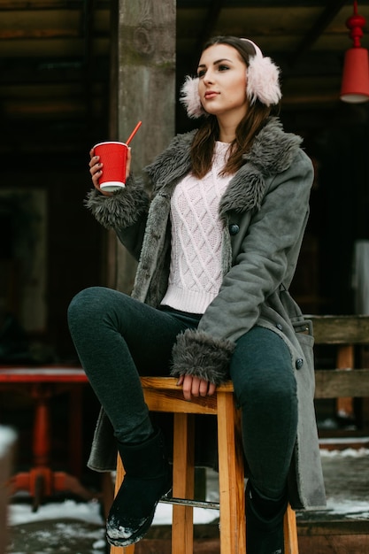 Ein schönes kaukasisches Mädchen, das heißen Kaffee trinkt