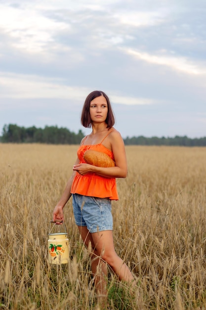 Ein schönes Mädchen in einem Feld mit Weizen Milch und Brot Peacetime Happiness Love