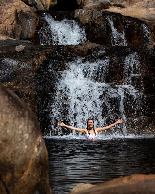 Ein schönes Mädchen in einem weißen Bikini schwimmt in einem natürlichen Pool in Jourama Falls, Queensland, Australien