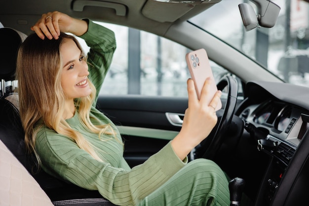 Ein schönes Mädchen macht ein Selfie im Auto