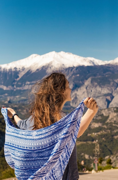 Ein schönes Mädchen vor dem Hintergrund der Berge ist mit einer Decke bedeckt