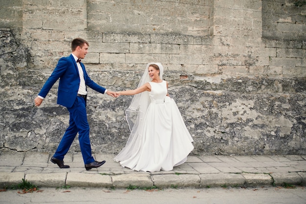 Ein schönes Paar Jungvermählten genießt an ihrem Hochzeitstag einen Spaziergang durch die Straßen der Altstadt