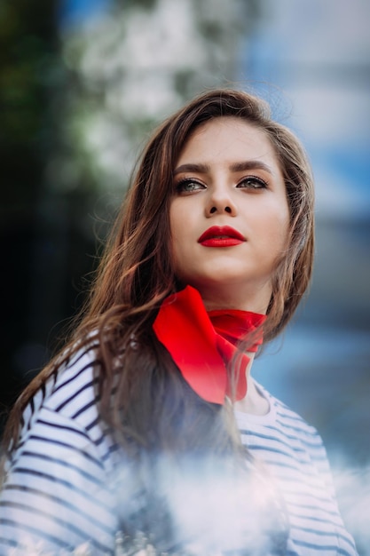 Ein schönes Porträt einer Frau mit leuchtend rotem Lippenstift und einem Schal herum