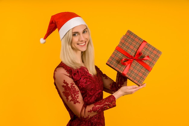 Ein schönes sexy Mädchen in einem Neujahrshut und einem grauen Kleid, halten in den Händen Geschenke