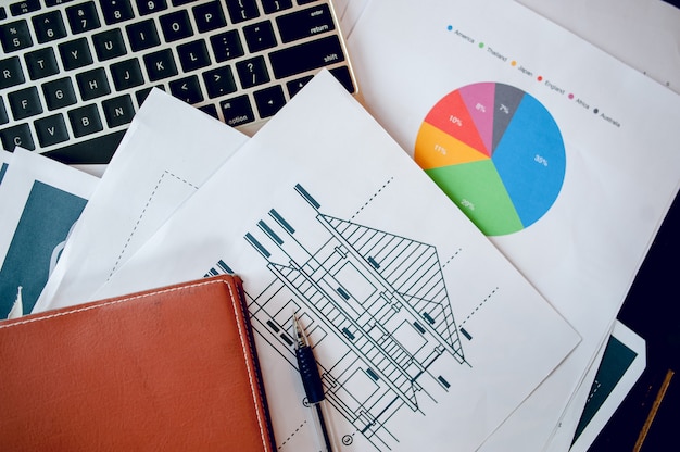 Ein Schreibtisch mit Business-Notebook, Diagramm und Tischplatte. Draufsicht mit Textfreiraum