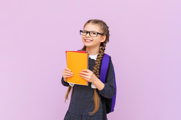 Ein Schüler hält Notizbücher auf einem rosa isolierten Hintergrund Ein Schulmädchen besucht Kurse, um ihr Wissen zu verbessern