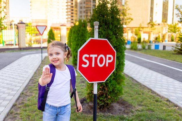 Foto ein schulmädchen mit einem stop-schild überquert die straße oder lernt die straßenregeln