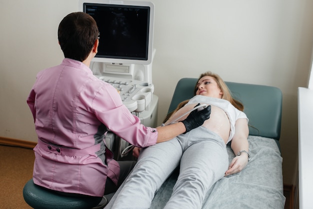 Ein schwangeres Mädchen bekommt in der Klinik einen Ultraschall ihres Bauches. Medizinische Untersuchung.