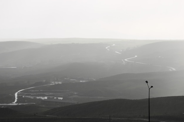 Ein Schwarz-Weiß-Foto von einer Straße und Bergen.