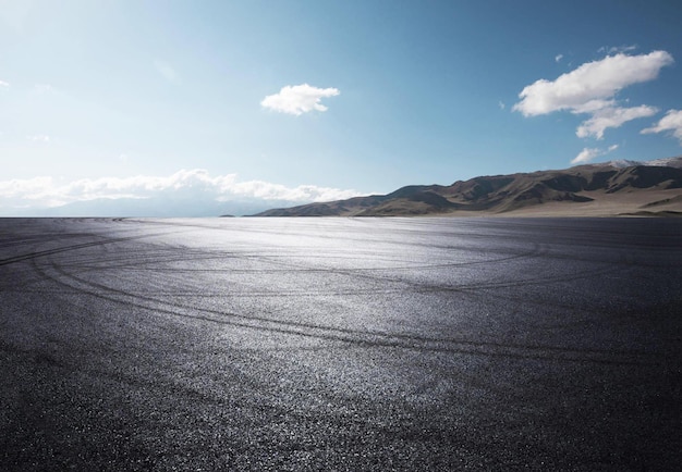 Ein schwarzer Asphalt mit der Aufschrift „Reifenspuren“ darauf