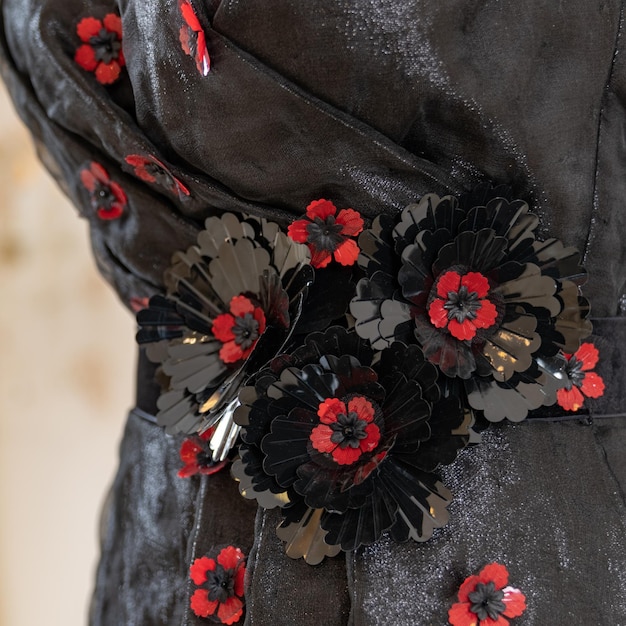 Ein schwarzes Kleid mit roten und schwarzen Blumen darauf.