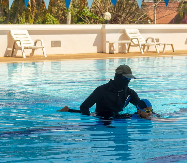 Foto ein schwimmlehrer unterrichtet einen jungen im pool