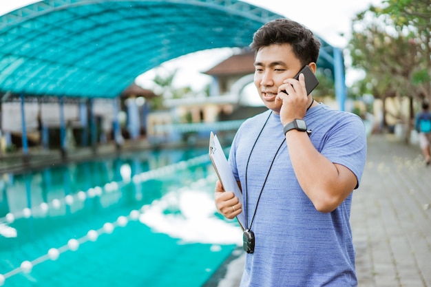 Ein Schwimmtrainer telefoniert mit einem Smartphone