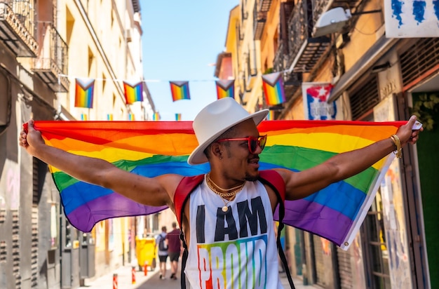 Ein schwuler schwarzer Mann, der mit einer LGBT-Flagge auf der Pride-Party spaziert