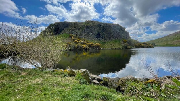 Ein See im Vordergrund mit einem Berg im Hintergrund