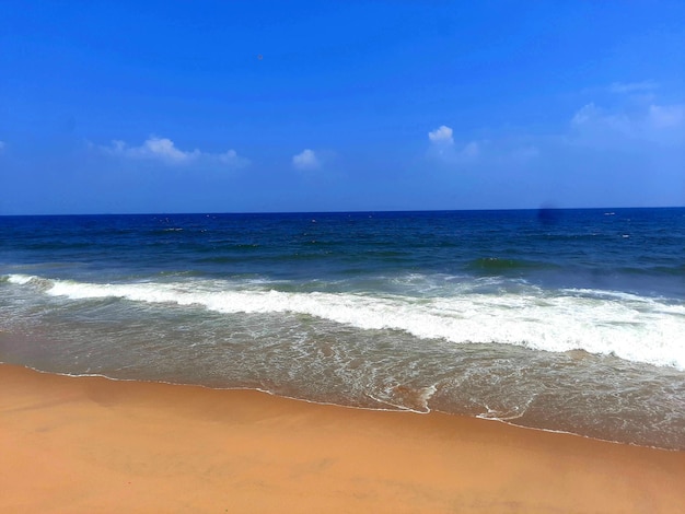 Ein Seestrand bewegt mit dem blauen Himmel wellenartig