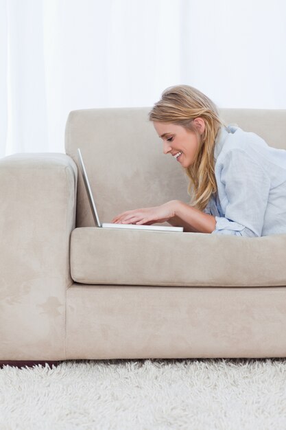 Foto ein seitenansichtschuß einer frau, die auf einem laptop schreibt