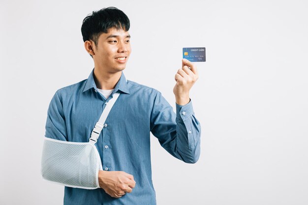 Ein selbstbewusster Mann, der mit einer Kreditkarte mit einem gebrochenen Arm fertig wird