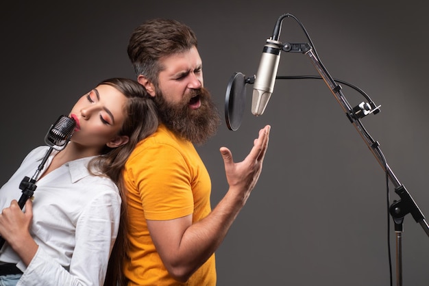 Ein singendes Sängerpaar führt ein Lied mit einem Mikrofon auf, während es in einem Musikstudio aufnimmt